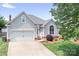 Inviting home featuring gray siding, lush landscaping, and an attached two-car garage at 141 Rose St, Mooresville, NC 28117
