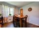 Inviting dining area with a wooden table set, a window with curtains, and light gray walls at 1410 Beverly Ave, Shelby, NC 28152