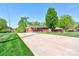 Spacious front yard with driveway leading up to a well-maintained brick home with lush greenery at 1410 Beverly Ave, Shelby, NC 28152