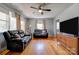 Spacious living room featuring hardwood floors, a ceiling fan, and comfortable black sofas at 1410 Beverly Ave, Shelby, NC 28152