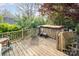 Wooden deck features a hot tub and a scooter, creating a spot for relaxation and recreation with natural surroundings at 1620 Edgefield Ave, Gastonia, NC 28052