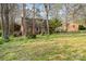 Charming brick home with mature trees and lush lawn on a sunny day, offering curb appeal and a peaceful setting at 1620 Edgefield Ave, Gastonia, NC 28052