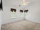 Bright bedroom featuring neutral carpeting, ceiling fan, and three sunny windows at 1694 Trotters Ridge Rd, Stanfield, NC 28163