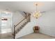 Foyer showcases a chandelier, staircase with wooden banister, chair rail and a comfortable wicker chair at 1694 Trotters Ridge Rd, Stanfield, NC 28163