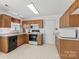 Bright kitchen features wooden cabinets, white appliances and tiled floor at 1694 Trotters Ridge Rd, Stanfield, NC 28163