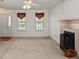 Bright living room features a ceiling fan, fireplace, two windows with decorative valances and neutral carpet at 1694 Trotters Ridge Rd, Stanfield, NC 28163