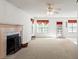Bright living room includes a fireplace, ceiling fan, neutral carpet, and abundant natural light at 1694 Trotters Ridge Rd, Stanfield, NC 28163