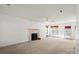 Bright living room features neutral carpet, fireplace with decorative screen, and multiple windows at 1694 Trotters Ridge Rd, Stanfield, NC 28163