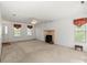Bright living room with neutral carpet, fireplace, ceiling fan, and natural light from multiple windows at 1694 Trotters Ridge Rd, Stanfield, NC 28163
