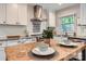 Bright kitchen featuring white cabinets, subway tile backsplash, stainless steel range hood, and butcher block island at 1702 Herrin Ave, Charlotte, NC 28205