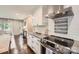 Modern kitchen featuring white cabinets, granite countertops, stainless steel appliances, and a stylish cooktop at 1702 Herrin Ave, Charlotte, NC 28205