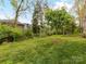 This backyard features a grassy area, several trees, and surrounding homes for a sense of community at 1805 Axholme Ct, Waxhaw, NC 28173
