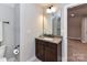 Bathroom features modern fixtures, a single vanity, gray walls, and wood-look tile flooring at 1805 Axholme Ct, Waxhaw, NC 28173