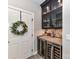 A custom dry bar includes glass shelving, mosaic backsplash, wine storage and under-counter wine refrigerator at 1805 Axholme Ct, Waxhaw, NC 28173