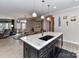 Open-concept kitchen with island seating, granite countertops, and stainless steel appliances overlooking the dining and living areas at 1805 Axholme Ct, Waxhaw, NC 28173