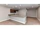 This kitchenette features granite countertops, a double sink, wooden cabinets, and a view into the recreation space at 1805 Axholme Ct, Waxhaw, NC 28173