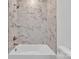 This bathroom features a bathtub with marble tile surround, a white toilet, and chrome fixtures at 208 Spinners Dr, Cherryville, NC 28021