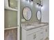 This primary bathroom features a double vanity with granite counters and round mirrors at 208 Spinners Dr, Cherryville, NC 28021