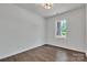 Bedroom features light walls, wood floors, a ceiling light, and a large window with views of a green yard at 208 Spinners Dr, Cherryville, NC 28021