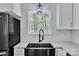 Close-up of the modern black kitchen sink, granite countertop, and large window, inviting the outdoors inside at 208 Spinners Dr, Cherryville, NC 28021
