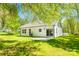 Rear exterior featuring a white home, a concrete patio, lush green grass, and mature trees at 208 Spinners Dr, Cherryville, NC 28021