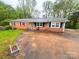 Quaint single-Gathering home featuring a brick facade, a metal roof, and classic black shutters at 2116 Dana Pl, Shelby, NC 28152