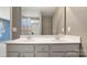 Bathroom vanity featuring double sinks and a large mirror reflecting a shower and window at 2120 Turtle Point Rd, Charlotte, NC 28262