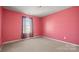 A carpeted bedroom with a window dressed with black curtains and pink walls at 2120 Turtle Point Rd, Charlotte, NC 28262
