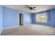 Light blue bedroom featuring a ceiling fan, neutral carpet, and a large window at 2120 Turtle Point Rd, Charlotte, NC 28262