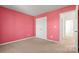 A carpeted bedroom with a double door closet and pink walls at 2120 Turtle Point Rd, Charlotte, NC 28262