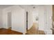 Bright hallway featuring hardwood floors, white walls, and access to multiple rooms and areas at 2120 Turtle Point Rd, Charlotte, NC 28262
