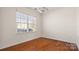Empty room featuring hardwood floors, neutral paint, a window, and a modern light fixture at 2120 Turtle Point Rd, Charlotte, NC 28262