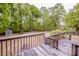 Back deck view of the wooden deck, with grassy yard, shed, and wooded perimeter at 2144 Newhart Rd, Charlotte, NC 28214