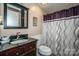Bathroom featuring vanity sink, toilet, medicine cabinet, and shower with purple curtain at 2144 Newhart Rd, Charlotte, NC 28214