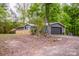 Exterior view of grey home, small shed, and a dark two car garage at 2144 Newhart Rd, Charlotte, NC 28214