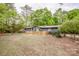 Quaint one-story home with natural landscaping surrounding its perimeter and a classic picket fence for added charm at 2144 Newhart Rd, Charlotte, NC 28214