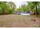 Spacious backyard with a well-maintained lawn, mature trees, and charming exterior back deck at 2144 Newhart Rd, Charlotte, NC 28214