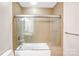 Bathroom with glass-enclosed tub-shower combo and tiled surround at 222 S Caldwell St # 1510, Charlotte, NC 28202