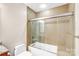 Bathroom features glass-enclosed tub-shower combo and tiled surround at 222 S Caldwell St # 1510, Charlotte, NC 28202
