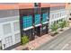 Modern building entrance features a dark facade, blue accents, and inviting landscaped accents at 222 S Caldwell St # 1510, Charlotte, NC 28202