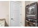 Modern stacked washer and dryer in the laundry room, next to a paneled door at 222 S Caldwell St # 1510, Charlotte, NC 28202