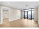 Open-concept living area features hardwood floors, neutral paint, and large windows to balcony at 222 S Caldwell St # 1510, Charlotte, NC 28202