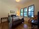 Comfortable bedroom featuring hardwood floors, a large window, and serene decor at 2309 Pinckney Ave, Charlotte, NC 28205
