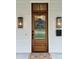 Close-up of a Craftsman-style front door with sidelights and a wreath, flanked by outdoor lighting fixtures at 2309 Pinckney Ave, Charlotte, NC 28205