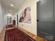 Hallway featuring hardwood floors, elegant artwork, and a view into the living room at 2309 Pinckney Ave, Charlotte, NC 28205