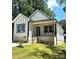 The new construction home features board and batten siding, a front porch with a blue door and modern landscaping at 2350 14Th Street Ne Ct, Hickory, NC 28601