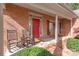 Charming brick home featuring a cozy front porch with rocking chairs and a welcoming red door at 255 Fernbrook Dr, Mooresville, NC 28117