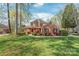 Beautiful two-story brick home with lush green lawn and mature trees, offering a serene and picturesque setting at 255 Fernbrook Dr, Mooresville, NC 28117
