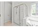 Clean bathroom with glass shower and separate soaking tub with a window view at 255 Fernbrook Dr, Mooresville, NC 28117