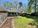 Landscaped backyard boasts a sunroom, stone patio with gazebo, and a well-manicured lawn at 271 Ikerd Se Dr, Concord, NC 28025